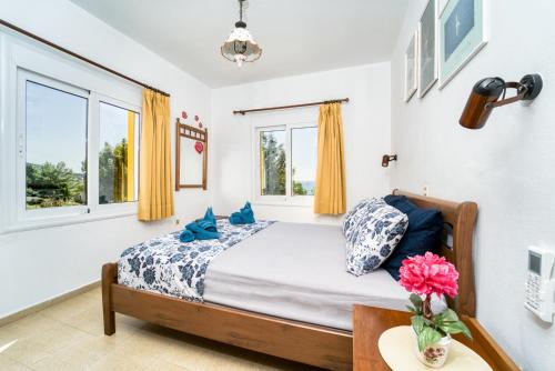 a bedroom with a bed with blue pillows and a table at Villa Lia Panorama in Pefki Rhodes