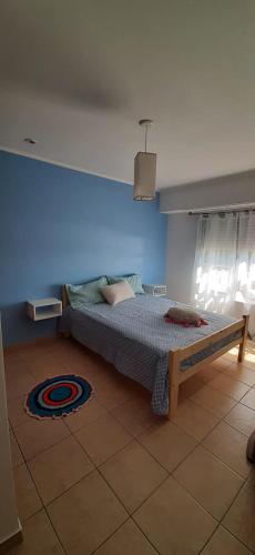 um quarto com uma cama com uma parede azul em DEPARTAMENTO LUMINOSO EUGENIO em Tandil