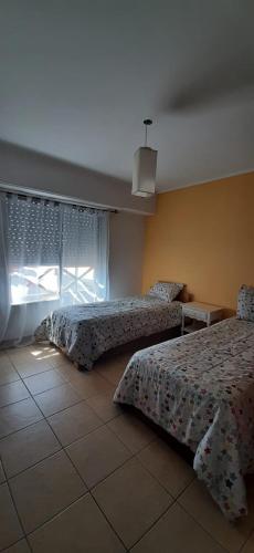 um quarto com 2 camas e uma janela em DEPARTAMENTO LUMINOSO EUGENIO em Tandil