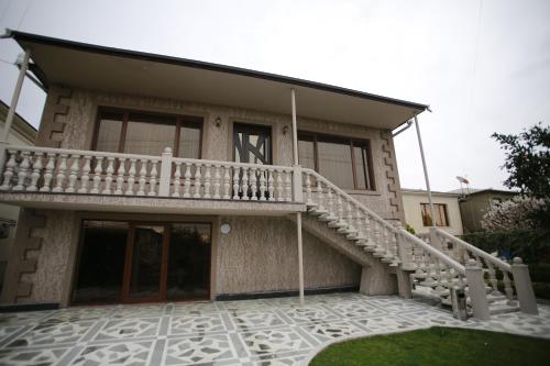 a house with a staircase in front of it at Guest House Nikola in Zugdidi