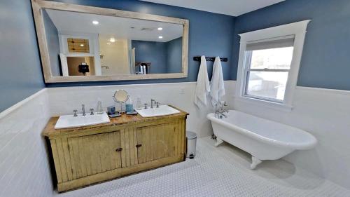 a bathroom with two sinks and a tub and a mirror at Linden Hills Luxury Charmer in Minneapolis