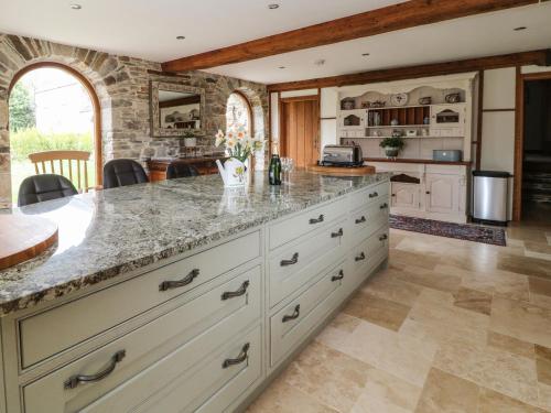an open kitchen with a large island with marble counter tops at Birchenhayes in Saltash