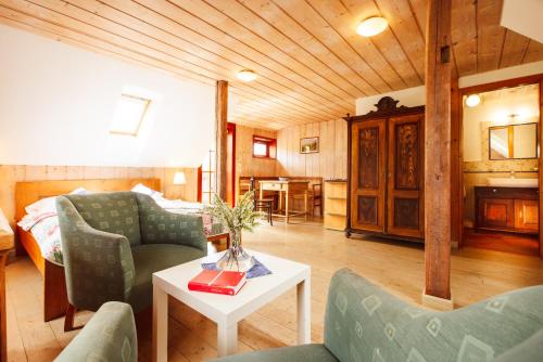 a living room with a bed and a table and chairs at Penzion Na Stodolci in Chřibská
