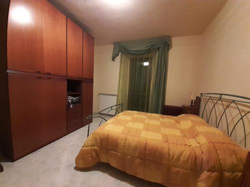 ein Schlafzimmer mit einem Bett, einer Kommode und einem Fenster in der Unterkunft Le Cortine in Roccatederighi