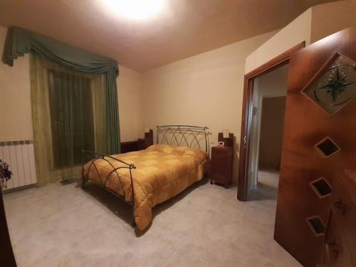 ein Schlafzimmer mit einem Bett mit einer goldenen Tagesdecke in der Unterkunft Le Cortine in Roccatederighi