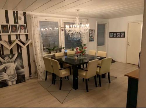 a dining room with a black table and chairs at Own private room in a big house! in Luleå