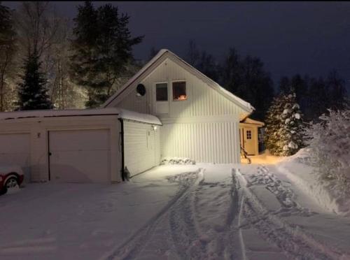 a house with a garage in the snow at night at Own private room in a big house! in Luleå