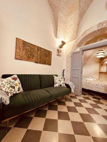 a living room with a green couch on a checkered floor at Casa in stile in Pezze di Greco