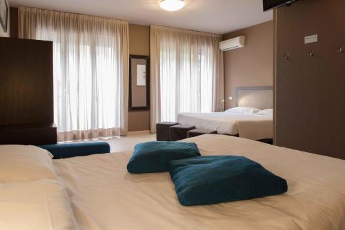 a hotel room with two beds with blue pillows on them at M14 Hotel & Spa in Padova