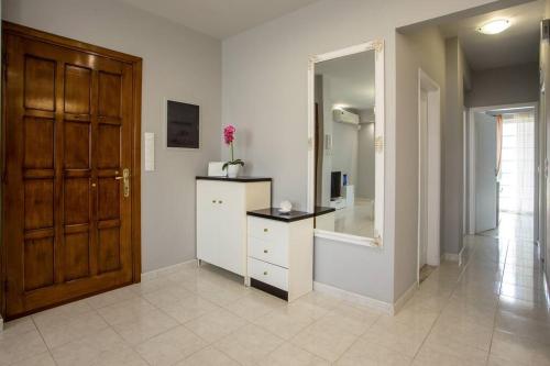 uma casa de banho com uma cómoda, um espelho e uma porta em Pelagia apartments in Ilha de Rhodes