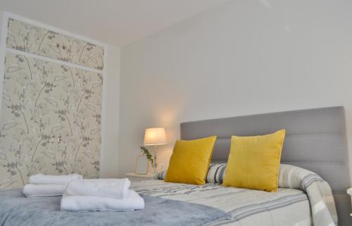 una camera da letto con letto e cuscini gialli di SunShine Tejares Garden a Cordoba
