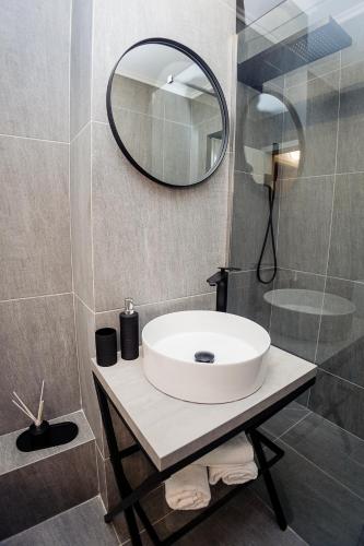 a bathroom with a white sink and a mirror at CooZee Apartment in Alba Iulia