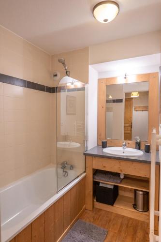 une salle de bain avec une baignoire et un lavabo et une baignoire dans l'établissement Appartement 6 couchages au pied des pistes à Orcières 2 chambres, balcon et parking couvert, à Orcières