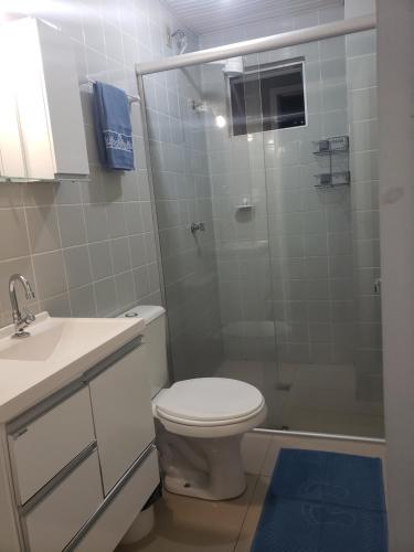 een badkamer met toilet en glazen douche bij Loft encantador próximo a Roda Gigante,excelente localização com ar condicionado in Balneário Camboriú
