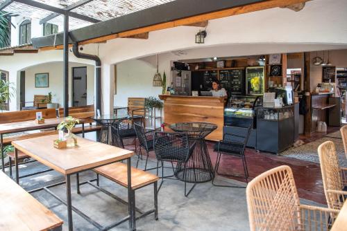 un restaurant avec des tables, des chaises et un comptoir dans l'établissement Believe Surf & Yoga Lodge Santa Teresa, à Santa Teresa