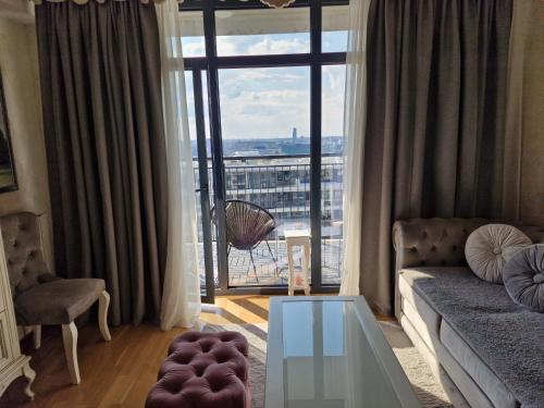 a living room with a couch and a large window at Beograd na vodi - BW ViSTA LUXURY in Belgrade