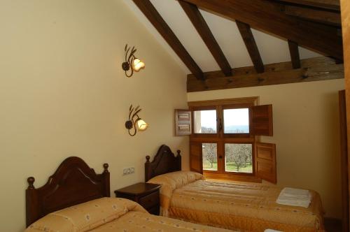 1 dormitorio con 2 camas y ventana en Alojamiento Rural El atardecer de Sanabria, en San Juan de la Cuesta