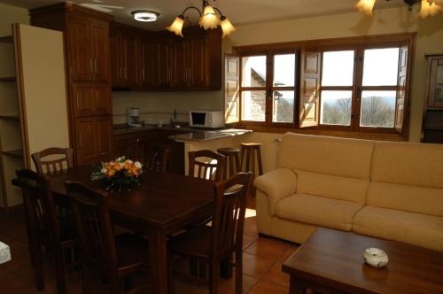 a kitchen and living room with a couch and a table at Alojamiento Rural El atardecer de Sanabria in San Juan de la Cuesta