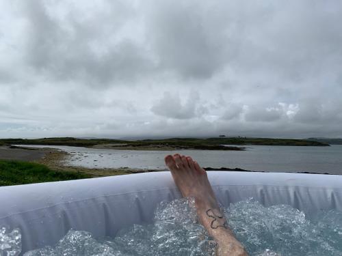 a persons foot in the water in a bath tub at Heir Island House in Skibbereen