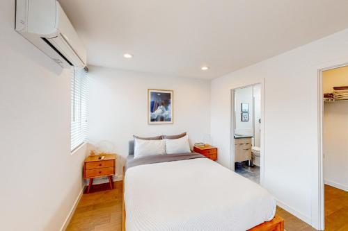 a white bedroom with a bed and a television at Northlake Nirvana in Seattle