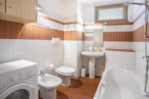 a bathroom with a toilet sink and a washing machine at La Maison in Bergamo