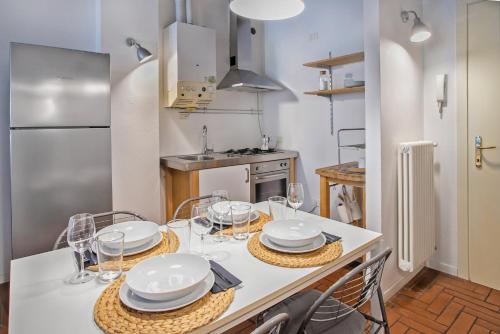 a kitchen with a table with plates and glasses on it at La Maison in Bergamo