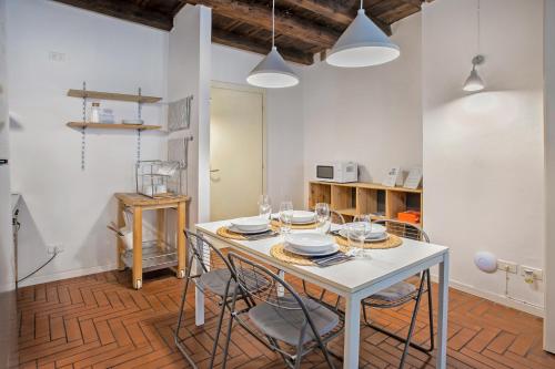 a dining room with a white table and chairs at La Maison in Bergamo