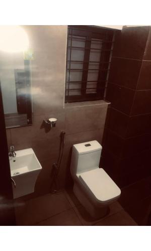 a bathroom with a white toilet and a sink at Redbell Inn Airport Hotel in Kondotti