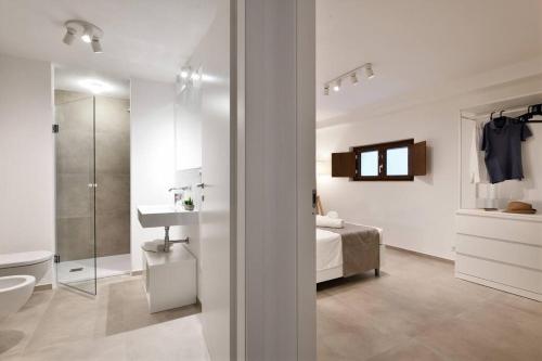 uma casa de banho branca com uma cama e um lavatório em Cosy and Modern Apartment Portu Frailis em Àrbatax