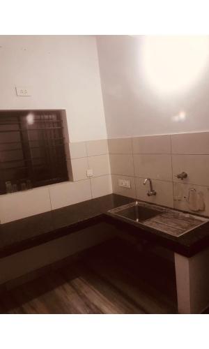 a bathroom with a sink and a mirror at Redbell Inn Airport Hotel in Kondotti