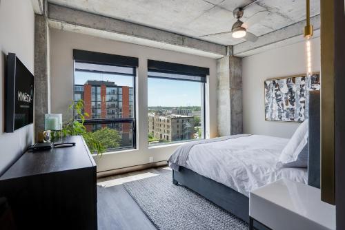 a bedroom with a bed and a large window at Sable 51 Luxury Two Story Loft in Minneapolis