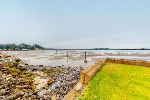 a view of a beach with water and grass at Sunset Beach House in Coos Bay