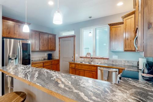 a kitchen with wooden cabinets and a granite counter top at Sunset Beach House in Coos Bay