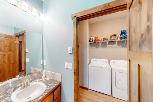 a bathroom with a sink and a washer and dryer at Sunset Beach House in Coos Bay