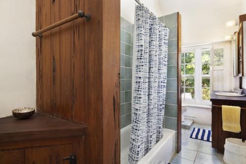 a bathroom with a wooden door and a bath tub at Tamarind home in Governorʼs Harbour