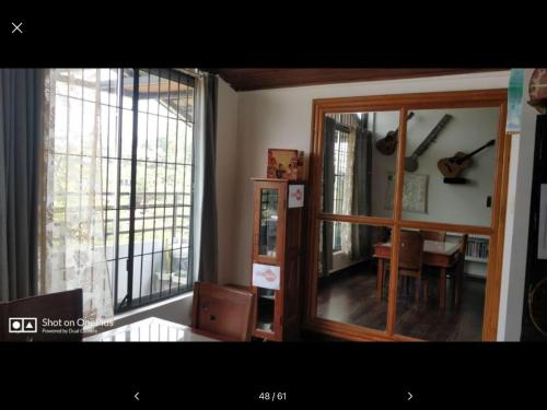 a room with a mirror and a table with a guitar at Coorg North Breeze Homestay in Madikeri