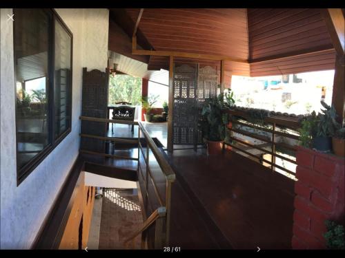 a porch of a house with a table and some plants at Coorg North Breeze Homestay in Madikeri