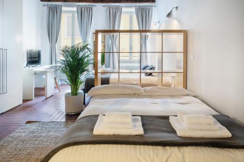 a bedroom with a large bed with two towels on it at La Maison in Bergamo