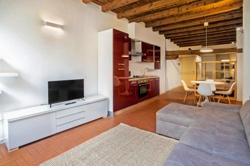 a living room with a couch and a flat screen tv at La Maison in Bergamo