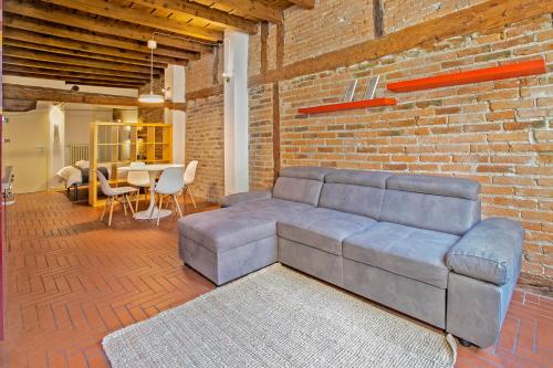 a living room with a couch and a brick wall at La Maison in Bergamo