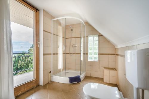 La salle de bains est pourvue d'une douche, de toilettes et d'une fenêtre. dans l'établissement Kerekhegy Vendégház, à Leányfalu