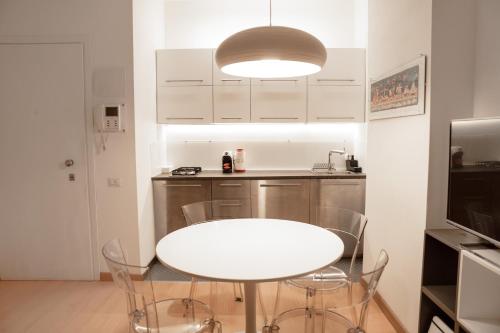 - une table et des chaises blanches dans une petite cuisine dans l'établissement Bubi House Porta Venezia, à Milan
