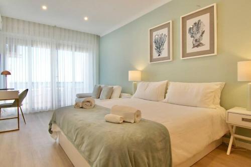 a bedroom with a large bed with two towels on it at Sea Lovers - Sea front - studio apartment in Monte Gordo