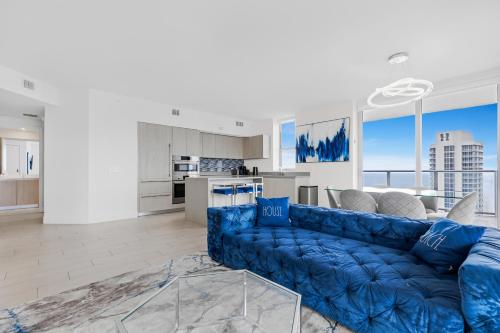 a living room with a blue couch and a kitchen at HYDE BEACH HOUSE - MILLIONAIRE 2 bd 2 ba APT, DIRECT OCEAN VIEW, 5 MIN WALK TO OCEAN in Hollywood
