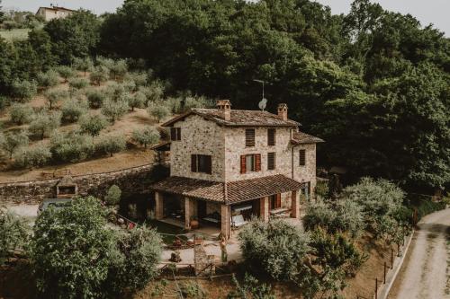 una casa vieja al lado de una colina en Agriturismo Tenuta Capitolini, en Collelungo