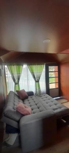 a large couch in a room with a window at Glamping y Cabañas el Encanto los Lirios in Tota