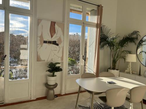 une salle à manger blanche avec une table et une fenêtre dans l'établissement Deux Pièces Luxe - Le Casanova, à Sète