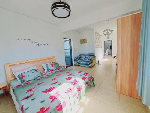 a bedroom with a bed with pink flowers on it at L'oiseau du Paradis in Balaclava