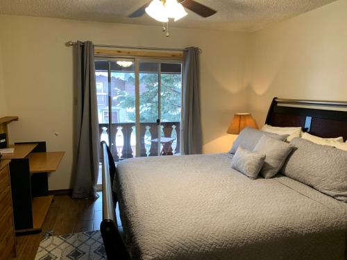 a bedroom with a bed and a window with a porch at Telemark #4 Townhouse On The River in Red River