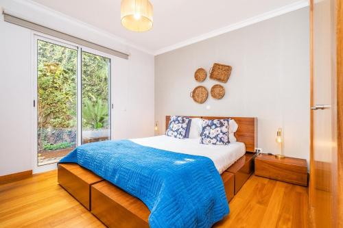 a bedroom with a bed and a large window at Home to Stay by Homie in Funchal